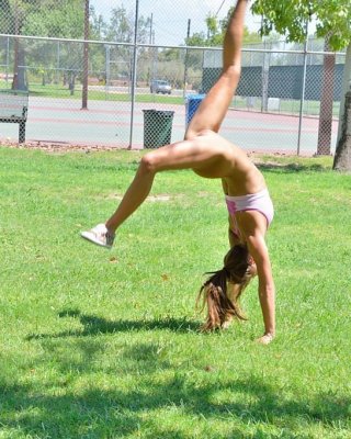 Cute gymnast does naked backflips by the tennis court #70972918