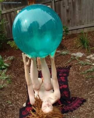 Behaarte Rothaarige Hippie spielt im Freien mit großem Aqua-Ball
 #77324176