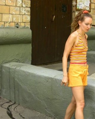 Unbequeme orangefarbene Shorts eines schlanken Mädchens, das zu stark pinkeln musste
 #73244622