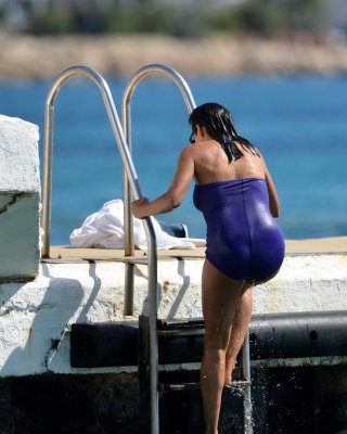 Rosario Dawson Shows Off Her Chubby Body Wearing A Purple Swimsuit  On The Pier 