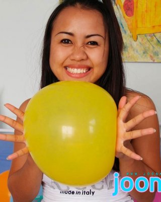 Süßes asiatisches Babe bläst gelbe Luftballons auf
 #69979778