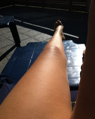 Beine und Füße in der Sonne auf dem Liegestuhl
 #97389993